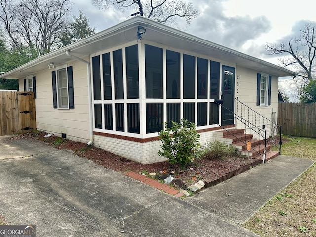 view of front of home featuring crawl space and fence