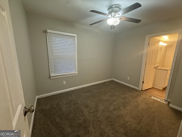 unfurnished bedroom featuring ceiling fan, baseboards, visible vents, and dark colored carpet