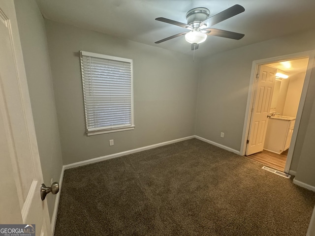 645 Steve Dr SW, Atlanta, GA 30315 - unfurnished bedroom featuring dark colored carpet and a ceiling fan