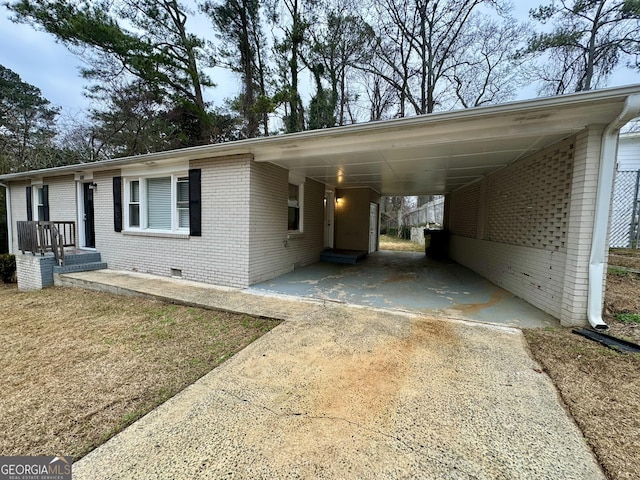 view of front of property featuring an attached carport, crawl space, brick siding, and driveway