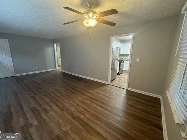 unfurnished living room featuring dark wood-style floors, a textured ceiling, and baseboards