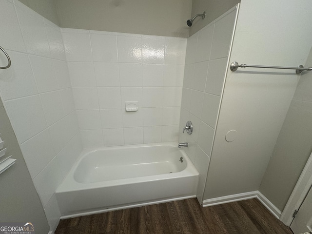 bathroom with tub / shower combination, baseboards, and wood finished floors