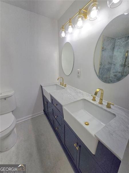 bathroom with toilet, double vanity, baseboards, and a sink