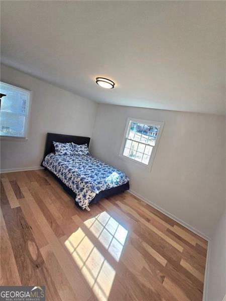 bedroom featuring wood finished floors and baseboards