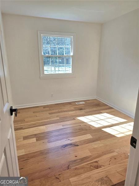 unfurnished room with wood finished floors and baseboards