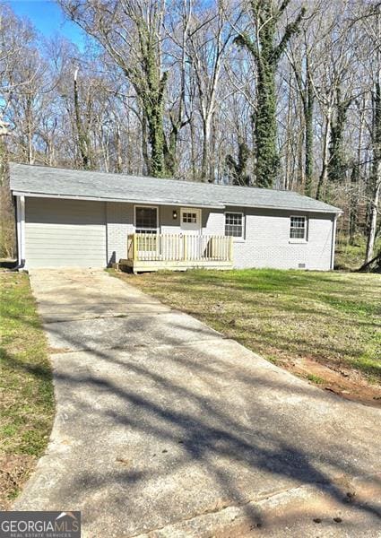 ranch-style home featuring concrete driveway and a front yard