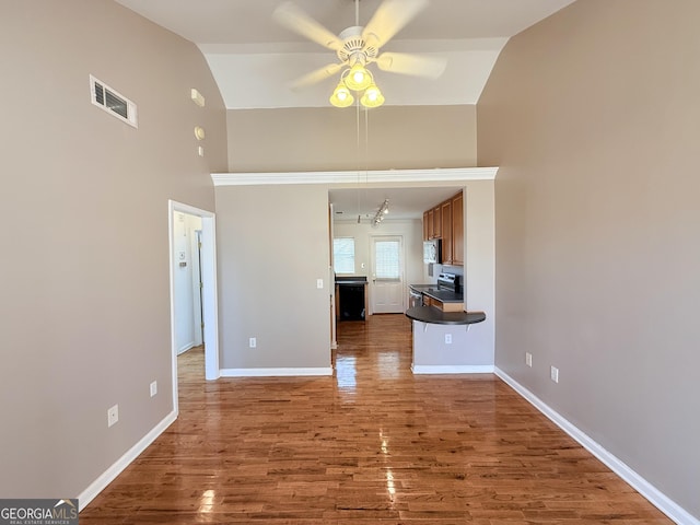 unfurnished living room with high vaulted ceiling, wood finished floors, a ceiling fan, visible vents, and baseboards