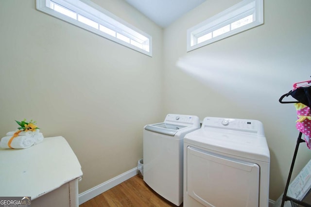 laundry area featuring light wood-type flooring, washing machine and dryer, laundry area, and baseboards