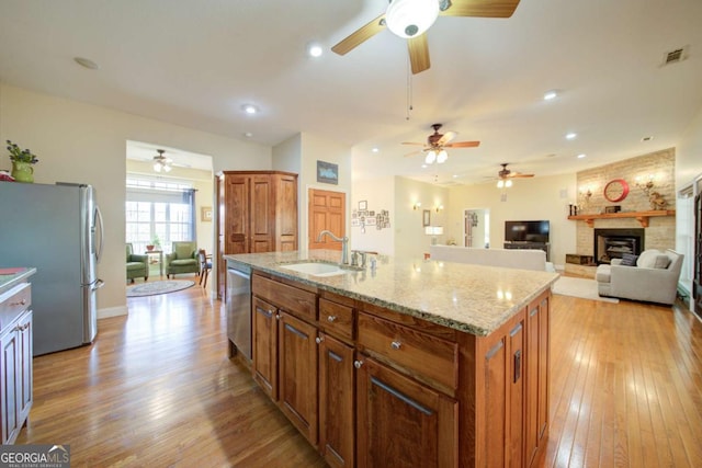2656 Panorama Dr, Sautee Nacoochee, GA 30571 - kitchen featuring stainless steel appliances, a sink, a large fireplace, a ceiling fan, and light wood-style floors