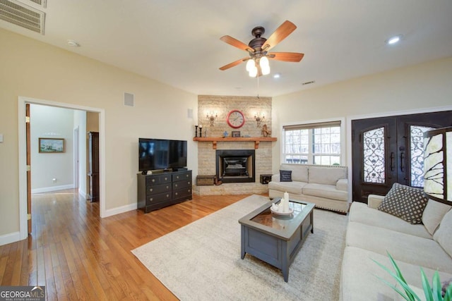 living area featuring light wood-style floors, visible vents, baseboards, and a ceiling fan