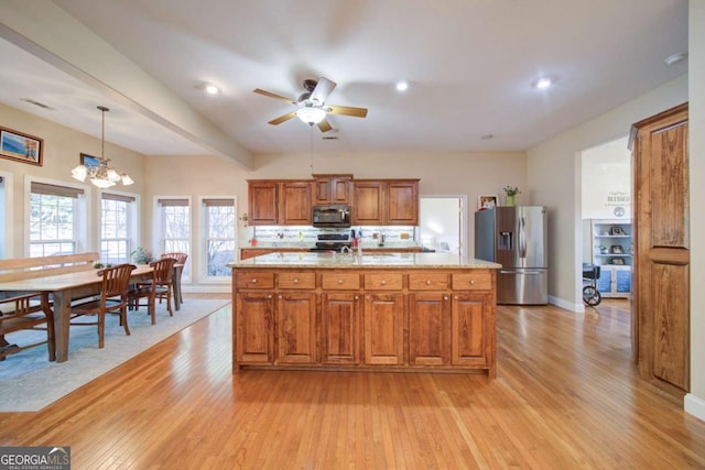 kitchen featuring stainless steel appliances, a center island, brown cabinetry, and decorative light fixtures