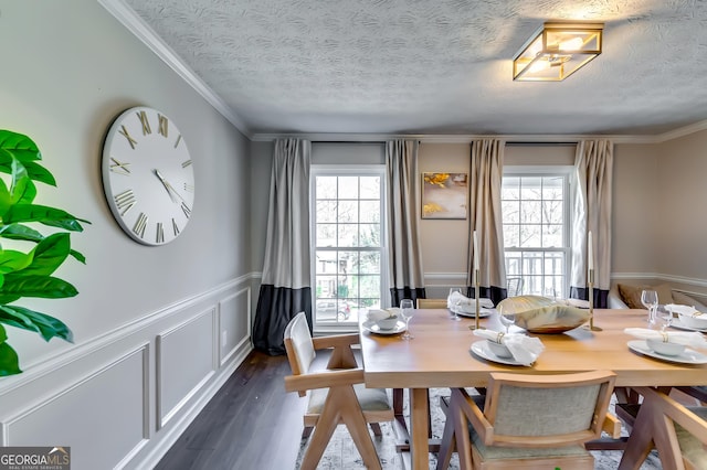 dining area with ornamental molding, a wainscoted wall, dark wood finished floors, and a textured ceiling