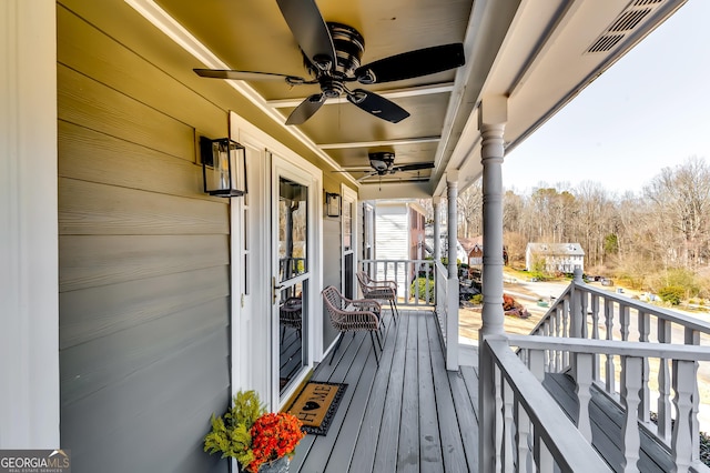 wooden terrace with ceiling fan and visible vents