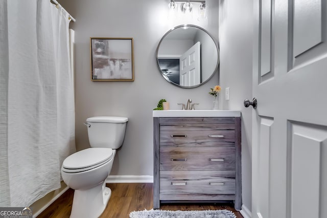 full bath with wood finished floors, vanity, toilet, and baseboards