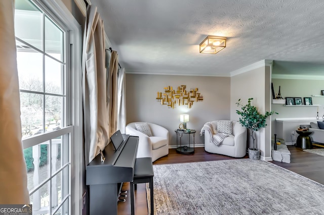 living area featuring crown molding, baseboards, dark wood finished floors, and a textured ceiling