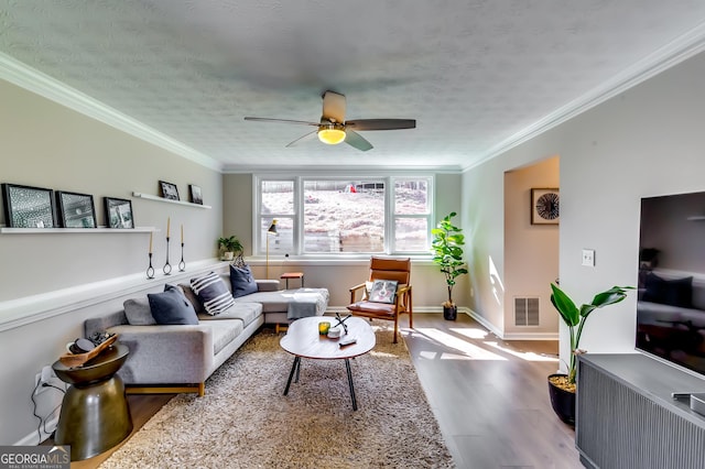 living room featuring visible vents, crown molding, a textured ceiling, and wood finished floors