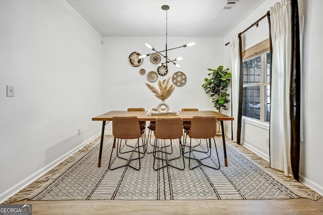 dining area featuring baseboards, an inviting chandelier, visible vents, and light wood-style floors