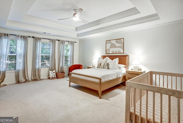 bedroom featuring crown molding, a tray ceiling, and carpet flooring