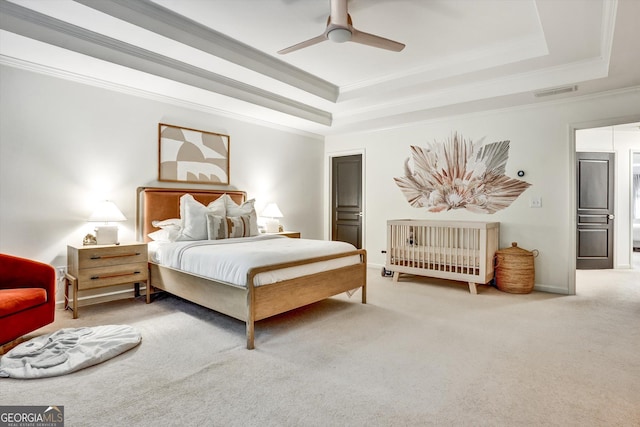 carpeted bedroom featuring ceiling fan, a raised ceiling, visible vents, and crown molding