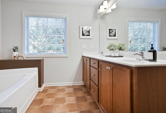 bathroom with a garden tub, a sink, baseboards, tile patterned floors, and double vanity