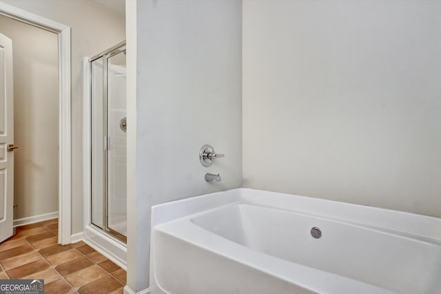 bathroom featuring a stall shower, a bath, and tile patterned floors