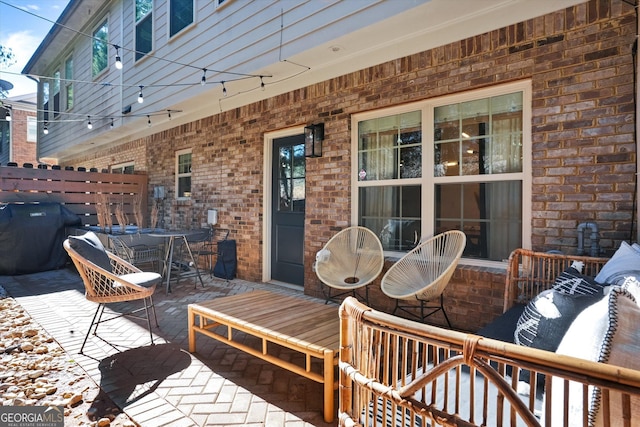 wooden deck with a grill and a patio