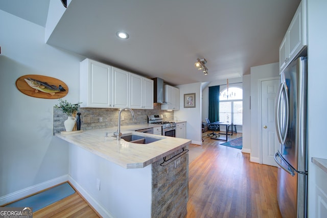 210 Wrights Mill Way, Canton, GA 30115 - kitchen with appliances with stainless steel finishes, a sink, light countertops, wall chimney exhaust hood, and decorative backsplash
