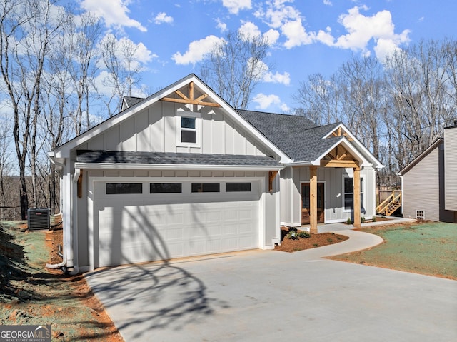 view of front of property featuring central air condition unit, a shingled roof, concrete driveway, board and batten siding, and a garage