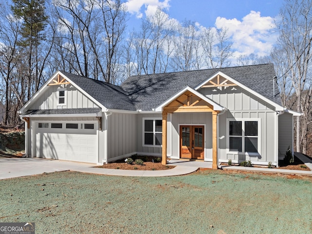 modern inspired farmhouse with driveway, an attached garage, board and batten siding, and french doors