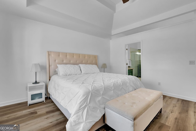 bedroom featuring ensuite bath, baseboards, and wood finished floors