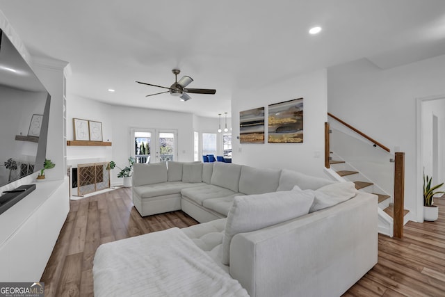 living area with stairs, a fireplace, wood finished floors, and recessed lighting