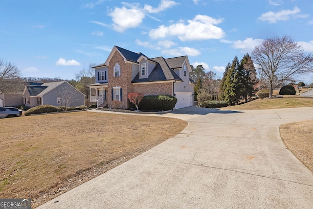 view of front of home with a garage, concrete driveway, brick siding, and a shingled roof