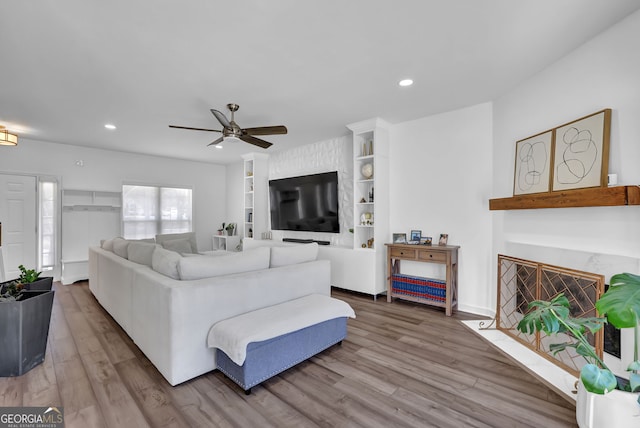 living room with a fireplace with flush hearth, recessed lighting, a ceiling fan, and wood finished floors