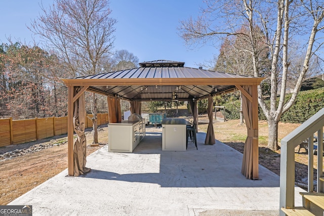 view of patio with a carport, a fenced backyard, and a gazebo