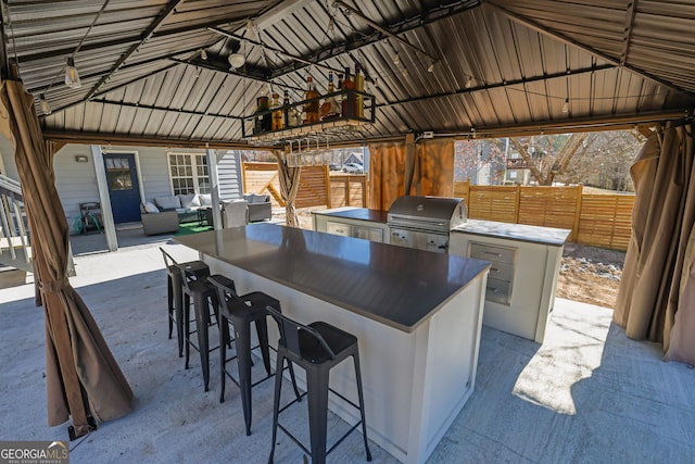 view of patio / terrace with outdoor lounge area, a gazebo, an outdoor kitchen, area for grilling, and fence