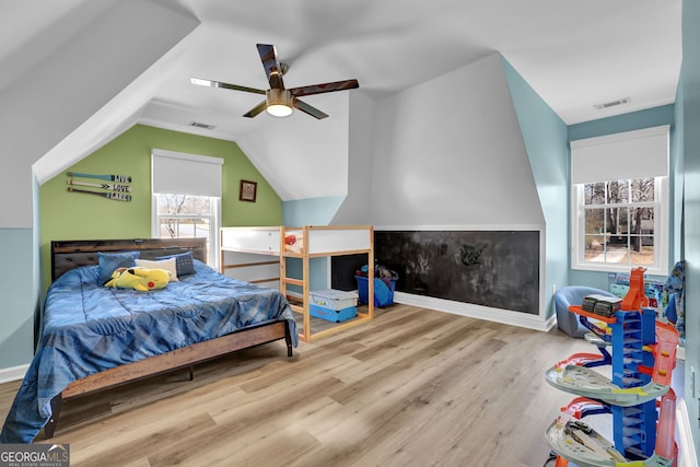 bedroom with lofted ceiling, ceiling fan, visible vents, and wood finished floors