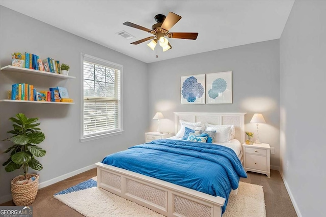 carpeted bedroom featuring a ceiling fan, visible vents, and baseboards