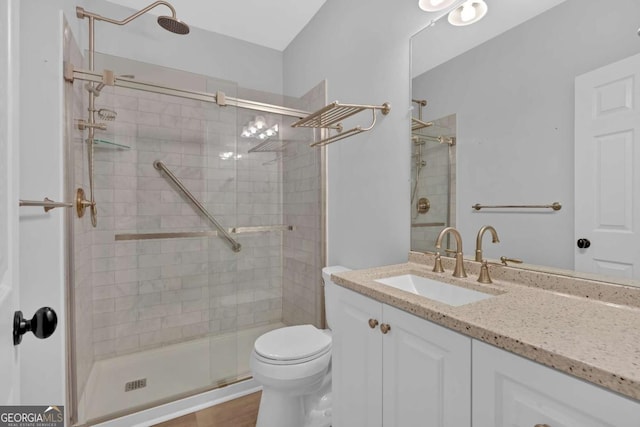 bathroom featuring a stall shower, vanity, and toilet