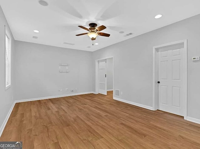 spare room with light wood-style floors, visible vents, baseboards, and a ceiling fan