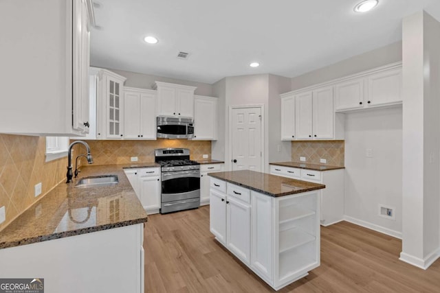 kitchen featuring stainless steel appliances, white cabinetry, and a center island