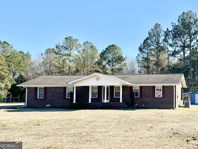 ranch-style house with a porch, a front lawn, cooling unit, and brick siding