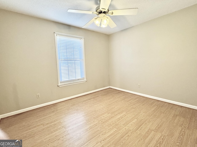 empty room with light wood finished floors, ceiling fan, baseboards, and a textured ceiling