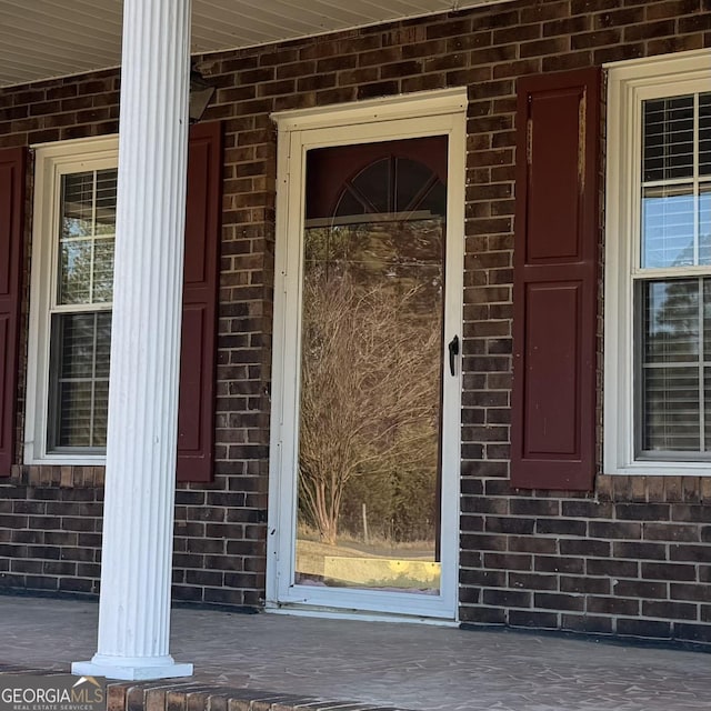 property entrance featuring brick siding