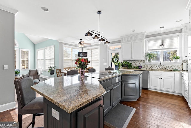 kitchen featuring dark wood-style floors, tasteful backsplash, white cabinets, and a center island