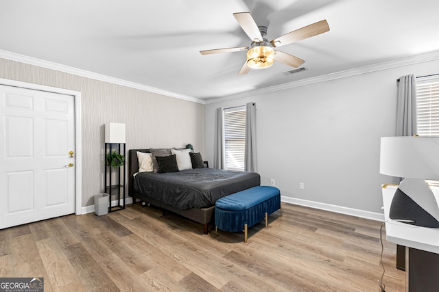 bedroom with ornamental molding, baseboards, visible vents, and light wood finished floors