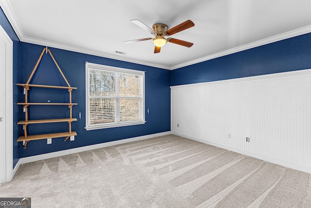 unfurnished room featuring ceiling fan, carpet, visible vents, and crown molding