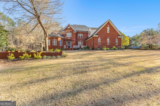 traditional-style home featuring brick siding and a front yard