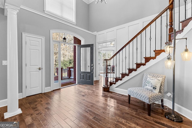 entryway with baseboards, hardwood / wood-style floors, and ornate columns