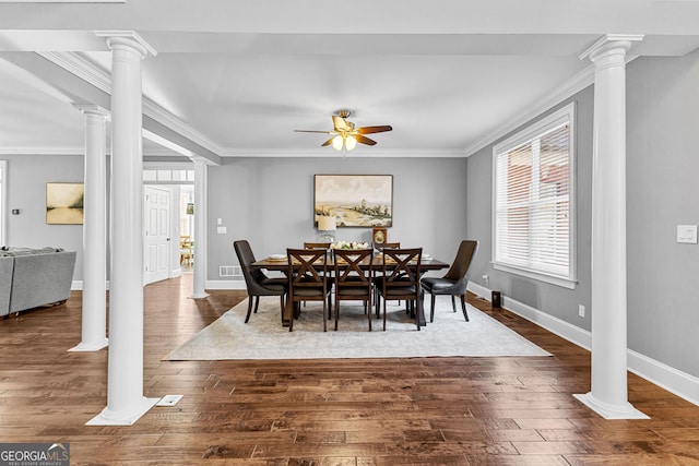 dining room featuring ornamental molding, dark wood-type flooring, and decorative columns