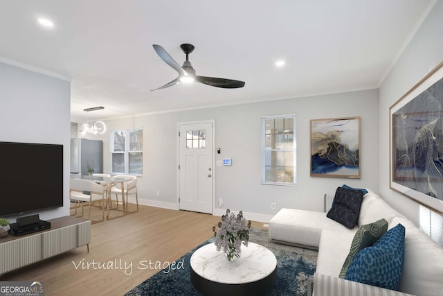 living room with baseboards, wood finished floors, a ceiling fan, and crown molding